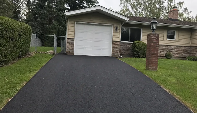 Same driveway freshly repaved with new asphalt in Arvada CO