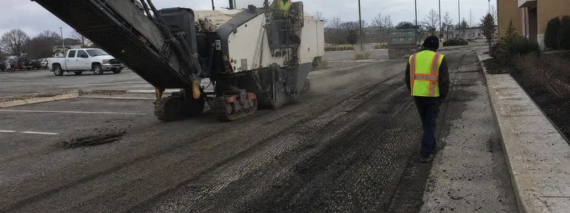 Asphalt milling machine grinding old pavement before resurfacing in Arvada Colorado