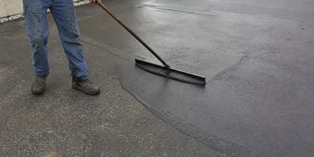 Squeegee applying driveway sealcoat on an Arvada CO driveway